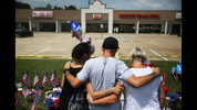 CHATTANOOGA, TN - JULY 18: People look on at a memorial setup in front of the Armed Forces Career Center/National Guard Recruitment Office which had been shot up on July 18, 2015 in Chattanooga, Tennessee. According to reports, Mohammod Youssuf Abdulazeez, 24, opened fire on the military recruiting station at the strip mall on July 16th and then drove more than seven miles away to an operational support center operated by the U.S. Navy and killed four United States Marines and a Navy sailor. The gunman was likely killed in a exchange of gunfire with the police. (Photo by Joe Raedle/Getty Images)